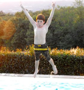 Boy jumping into pool
